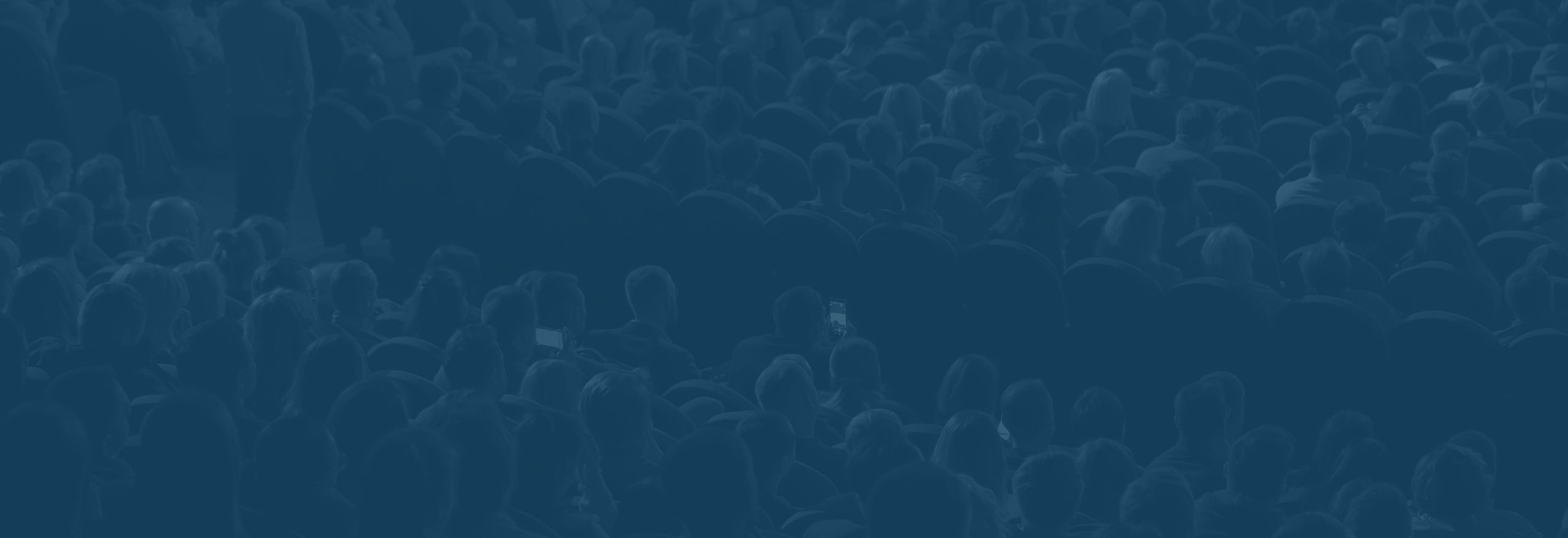 Seitenansicht von Zuschauern bei einem Vortrag mit blauem Overlay